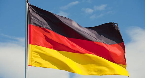 german flag on a pole over beautiful sky